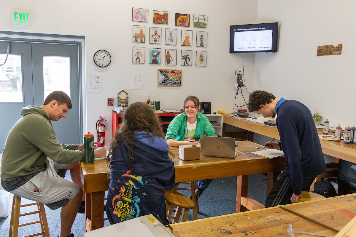 students and teacher at table in art workshop